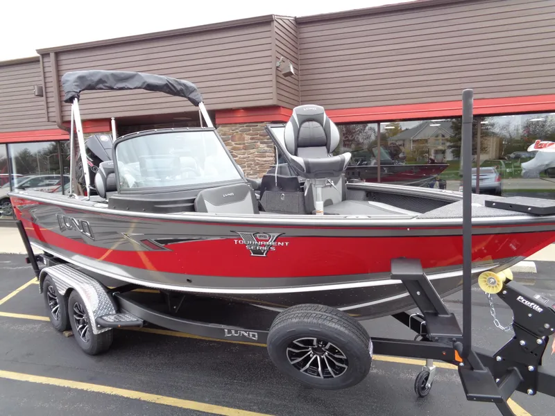 Slide: The Image of 2025 Lund 1975 Pro-V boat, red and black, parked on a trailer. - 3