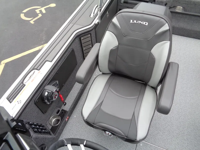 Slide: The Image of Lund 1975 Pro-V 2025 boat interior with gray captain's chair and control panel. - 36