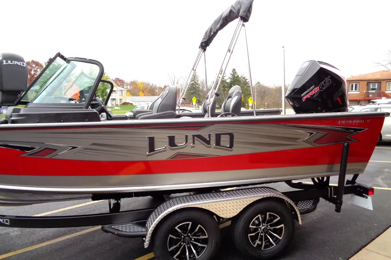 Slide: The Image of 2025 Lund 1975 Pro-V boat with red and silver design on a trailer. - 5