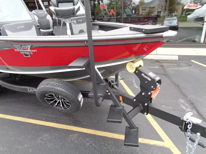Slide: The Image of Red 2025 Lund 1975 Pro-V boat on trailer in parking lot. - 8