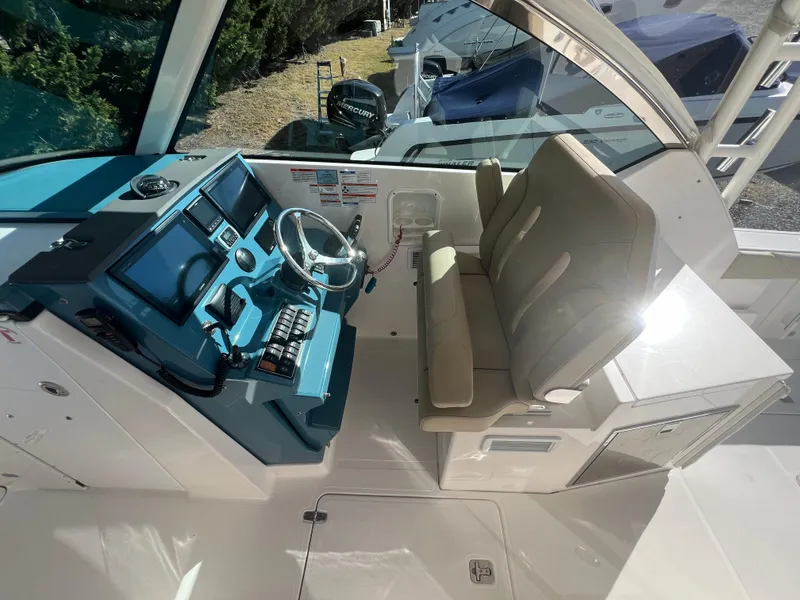 Slide: The Image of 2017 Pursuit 325 DC Dual Console boat interior with helm and seating area. - 11