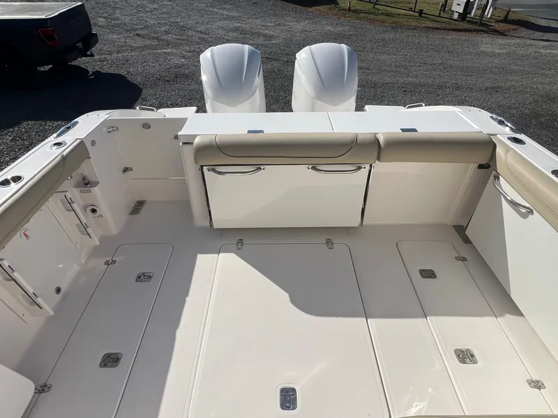 Slide: The Image of 2017 Pursuit 325 DC Dual Console boat deck with twin engines, spacious seating, and storage. - 13