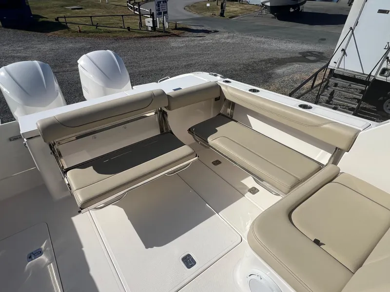 Slide: The Image of 2017 Pursuit 325 DC Dual Console boat interior with beige seating and twin engines. - 14