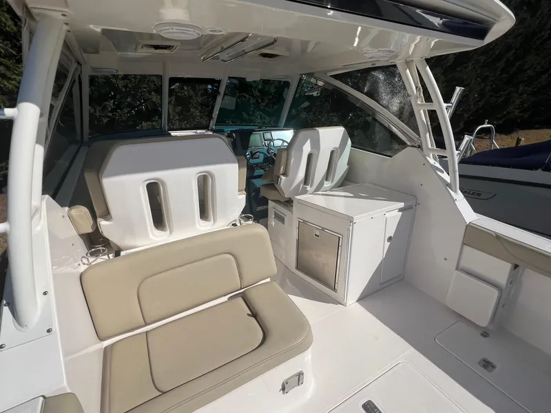 Slide: The Image of 2017 Pursuit 325 DC Dual Console boat interior with seating and storage. - 15