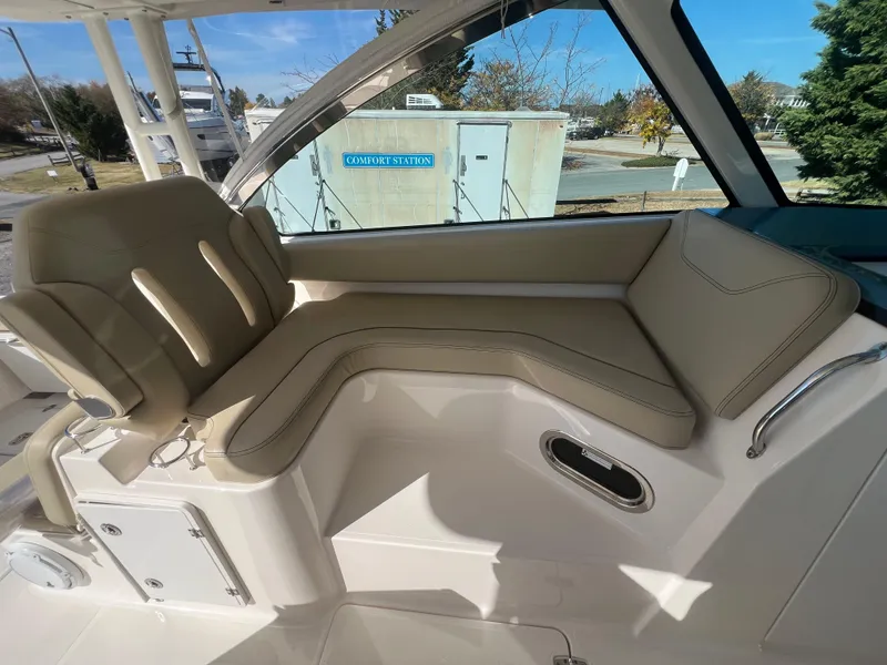 Slide: The Image of 2017 Pursuit 325 DC Dual Console boat interior with beige seating. - 16