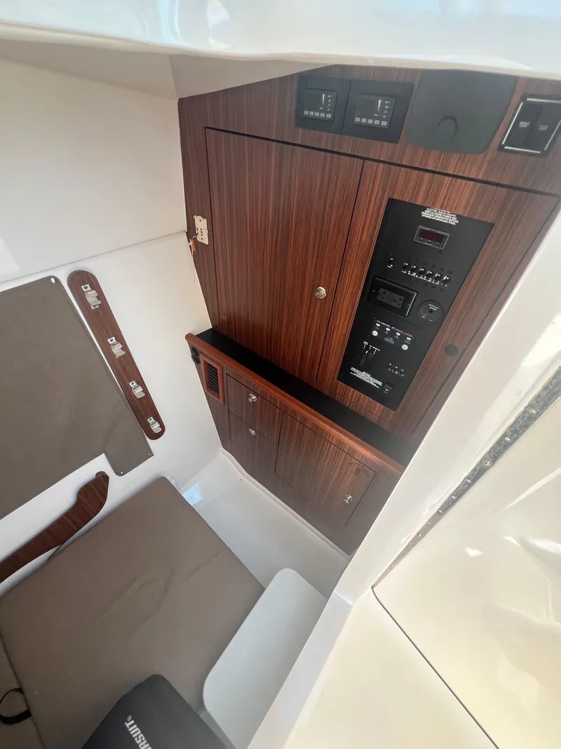Slide: The Image of 2017 Pursuit 325 DC Dual Console cabin interior with wood paneling and control panel. - 23