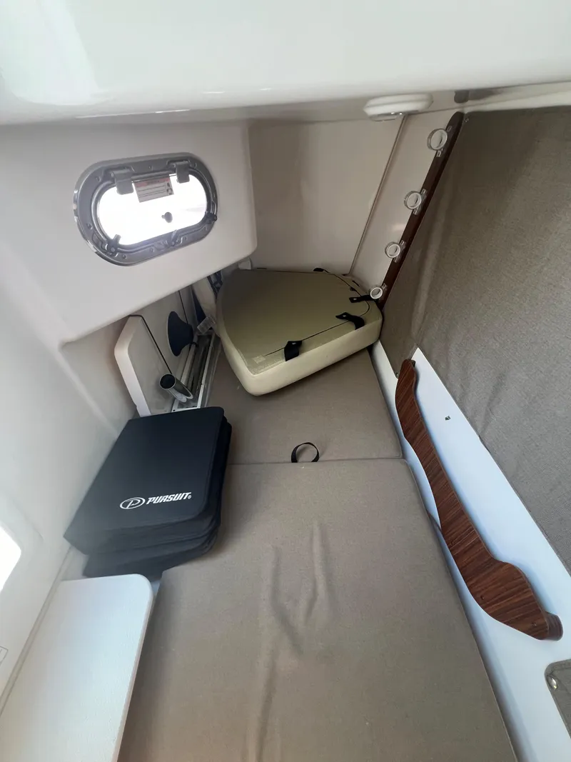 Slide: The Image of Interior cabin of 2017 Pursuit 325 DC Dual Console boat, featuring storage and seating. - 24