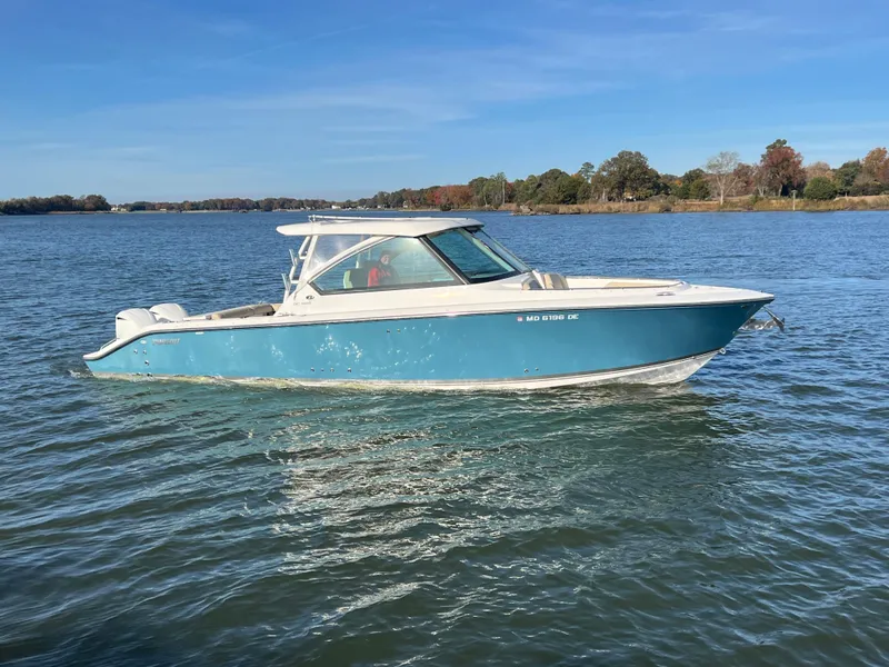 Slide: The Image of 2017 Pursuit 325 DC Dual Console boat on calm water. - 26