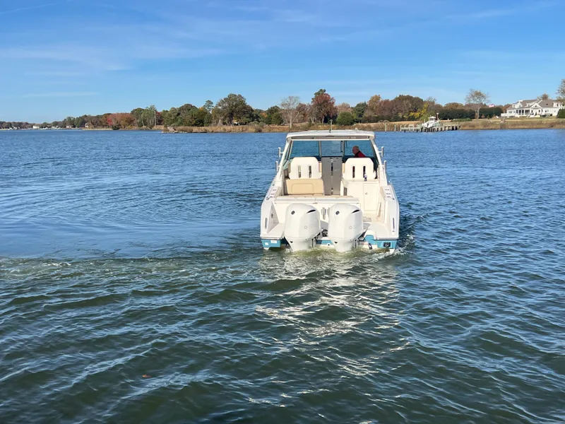 Slide: The Image of 2017 Pursuit 325 DC Dual Console boat cruising on a serene lake. - 28
