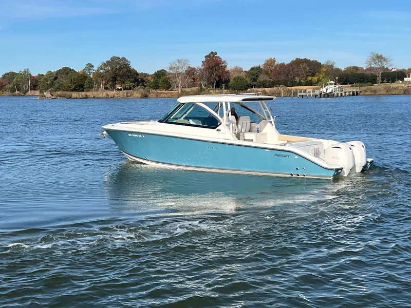 Slide: The Image of 2017 Pursuit 325 DC Dual Console boat cruising on a calm lake. - 31