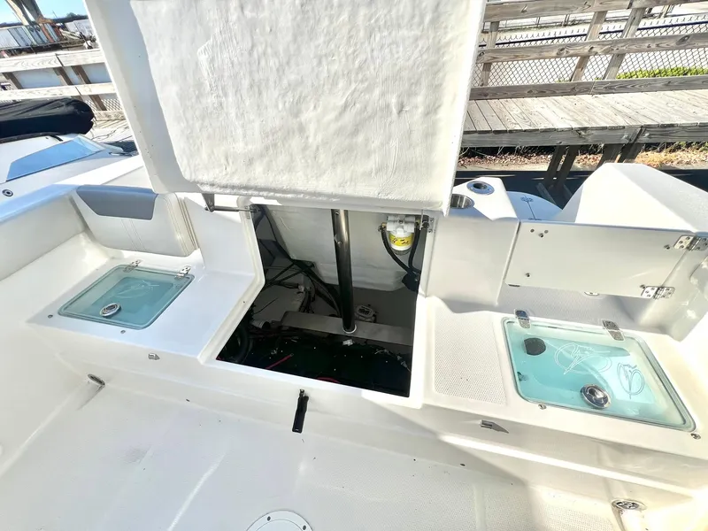 Slide: The Image of 2025 Sailfish 232 CC boat interior with steering wheel and seating, docked near a bridge. - 4