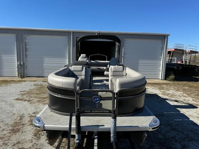 Slide: The Image of 2024 Premier 250 Sunsation pontoon boat parked outside storage units. - 12