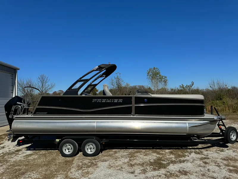 Slide: The Image of 2024 Premier 250 Sunsation pontoon boat on trailer, parked outdoors under clear blue sky. - 8