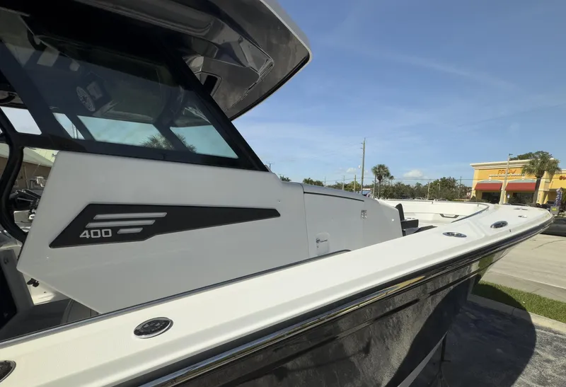 Slide: The Image of 2024 Blackfin 400 CC boat, sleek design, docked under clear blue sky. - 17