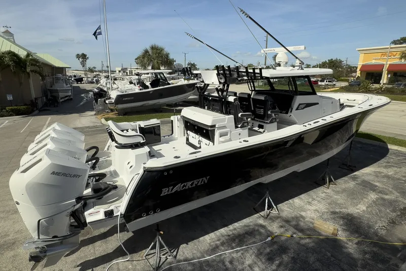 Slide: The Image of 2024 Blackfin 400 CC boat with triple Mercury engines on display outdoors. - 2