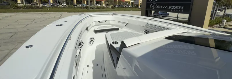 Slide: The Image of 2024 Blackfin 400 CC boat deck with seating and speakers, displayed outdoors. - 33