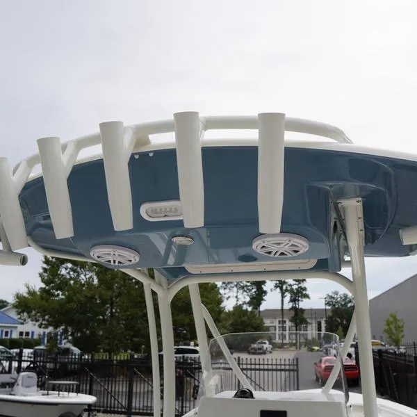 Slide: The Image of 2025 Cobia 220 Center Console boat with rod holders and speakers. - 13