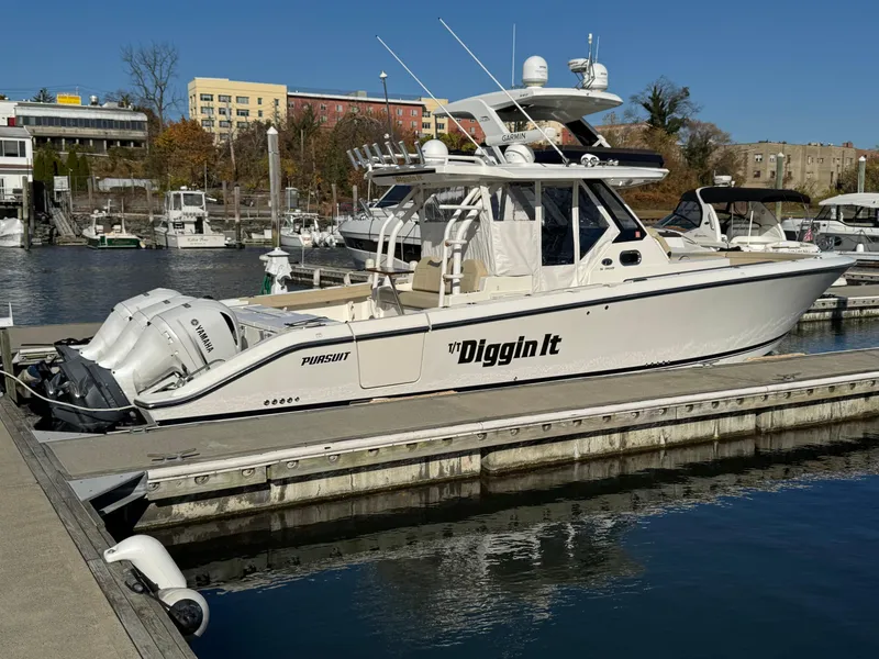 Slide: The Image of 2019 Pursuit S 368 Sport boat docked in marina, clear sky, calm water. - 0