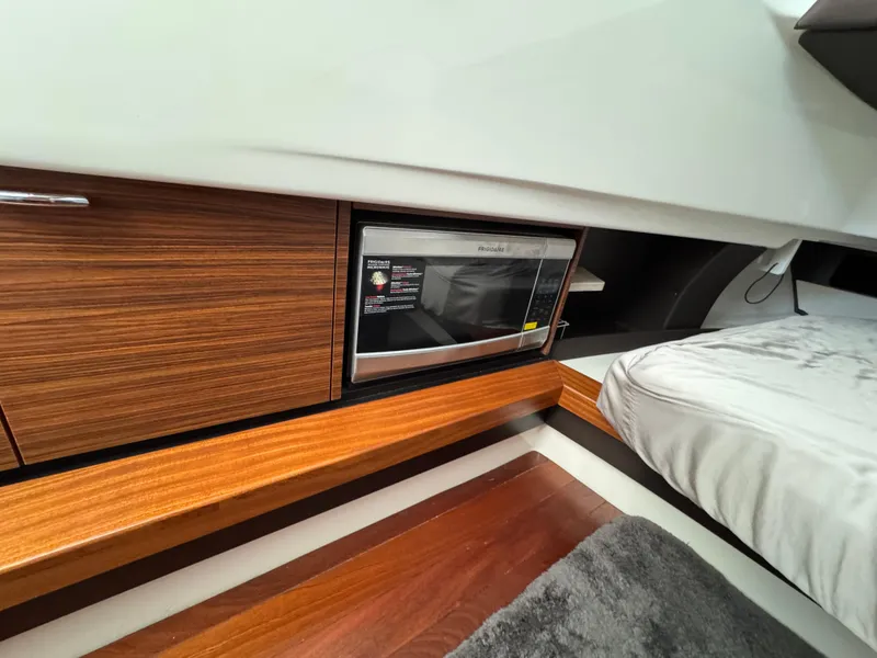 Slide: The Image of 2019 Pursuit S 368 Sport interior with microwave and wooden cabinetry. - 17