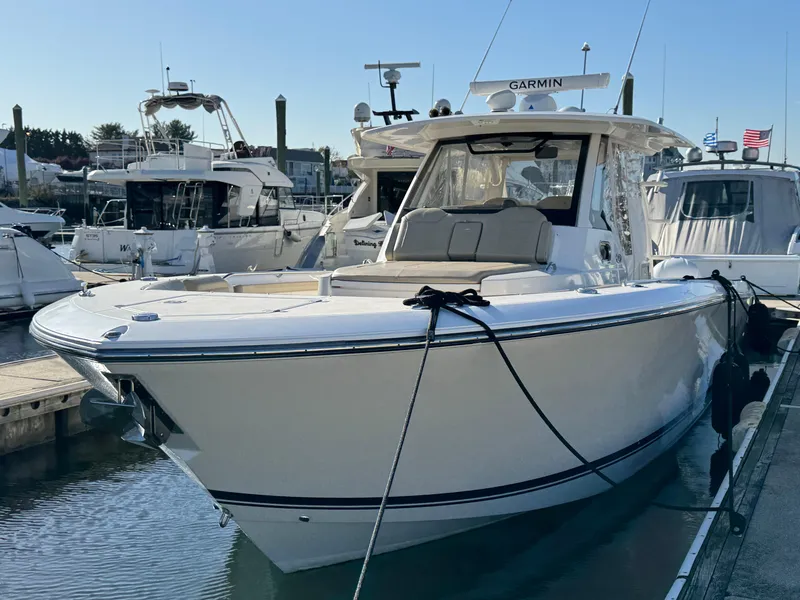 Slide: The Image of 2019 Pursuit S 368 Sport boat docked in marina, featuring sleek design and modern equipment. - 2