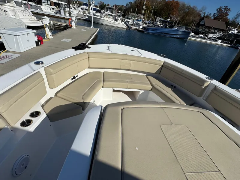 Slide: The Image of 2019 Pursuit S 368 Sport boat with beige seating at a marina dock. - 20