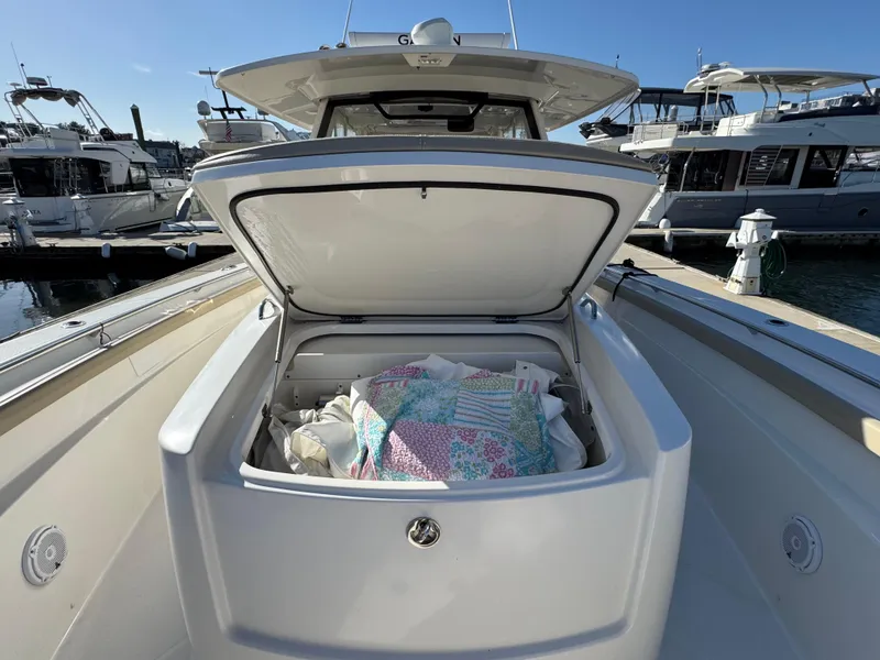 Slide: The Image of 2019 Pursuit S 368 Sport boat with open storage compartment at marina. - 22