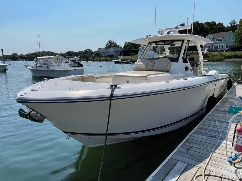 Slide: The Image of 2019 Pursuit S 368 Sport boat docked in a serene marina setting. - 24