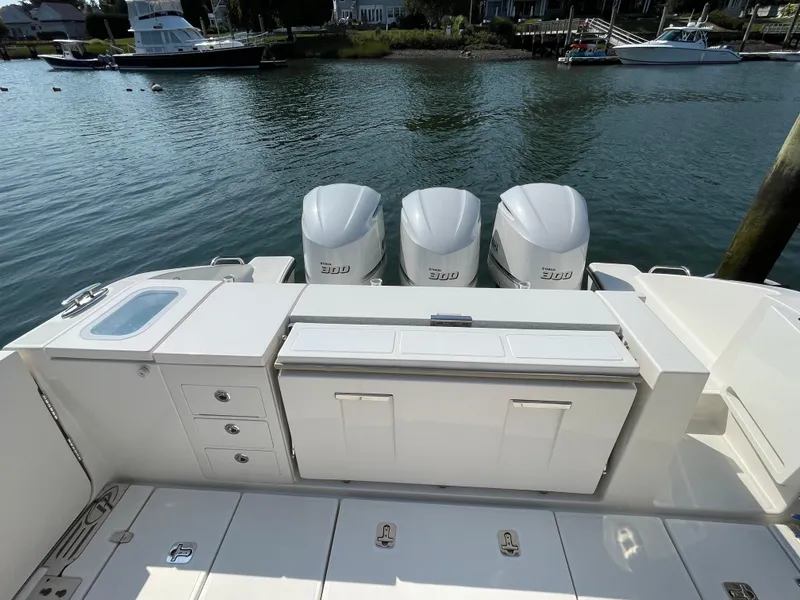 Slide: The Image of 2019 Pursuit S 368 Sport boat with triple engines, docked by the water. - 26