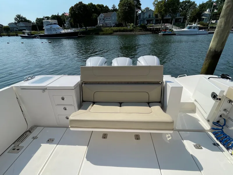 Slide: The Image of 2019 Pursuit S 368 Sport boat with seating, docked by a scenic waterfront. - 27