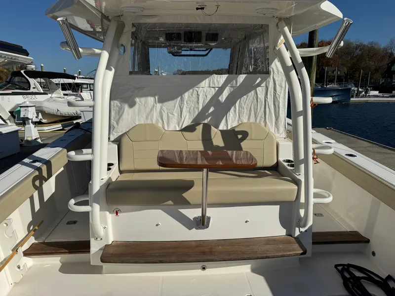 Slide: The Image of 2019 Pursuit S 368 Sport boat interior with seating and table, docked at marina. - 3