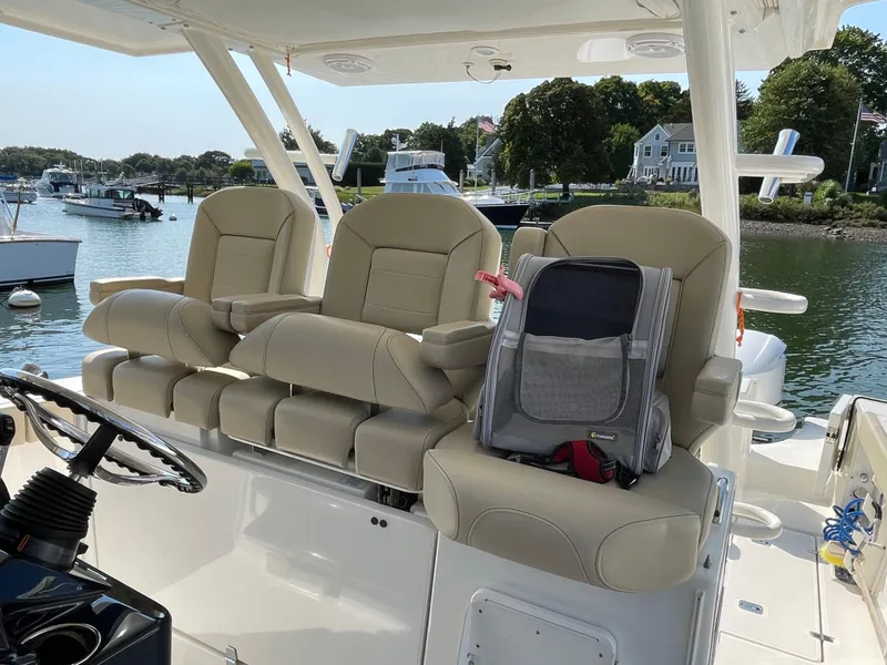 Slide: The Image of 2019 Pursuit S 368 Sport boat interior with beige seats and a backpack. - 33