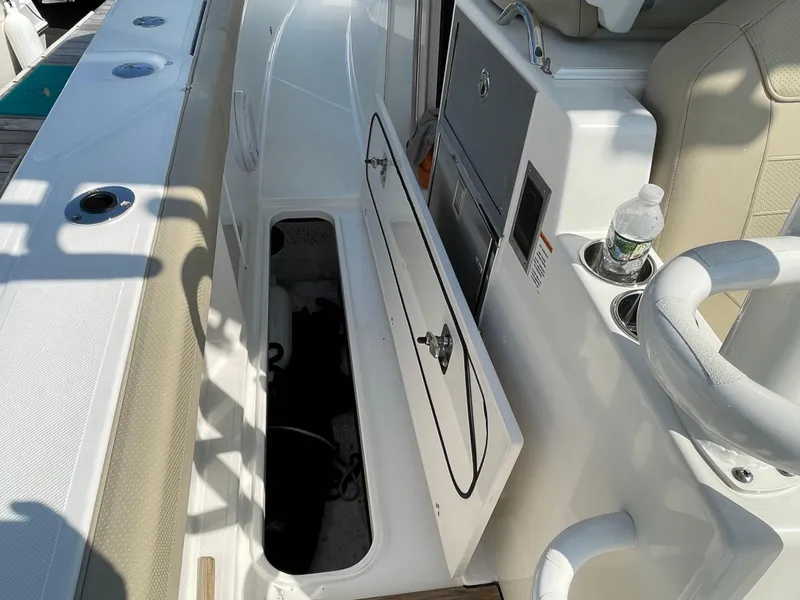 Slide: The Image of 2019 Pursuit S 368 Sport boat interior with open storage compartment and seating area. - 34