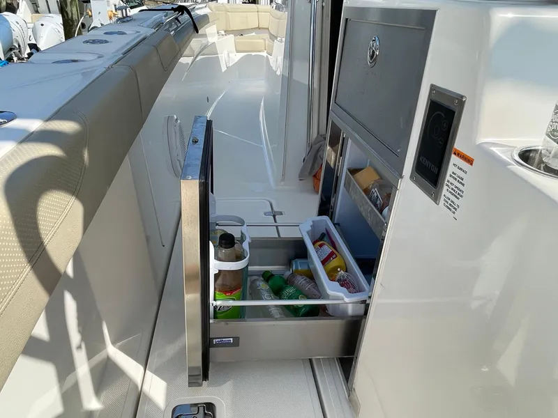 Slide: The Image of 2019 Pursuit S 368 Sport boat with open storage compartment and beverages. - 35