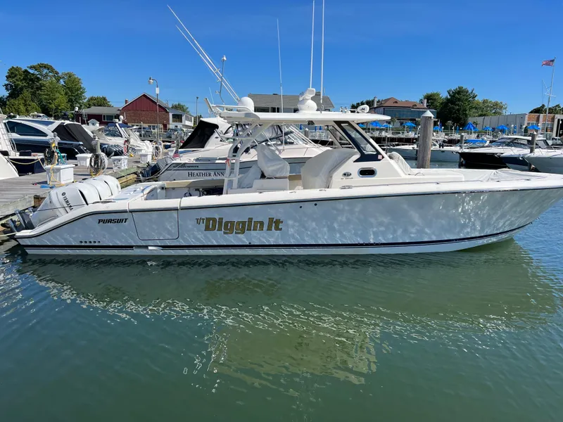Slide: The Image of 2019 Pursuit S 368 Sport boat docked in marina, clear sky, calm water. - 38
