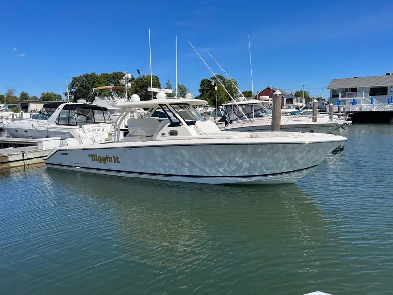 Slide: The Image of 2019 Pursuit S 368 Sport boat docked in a marina under clear blue skies. - 39