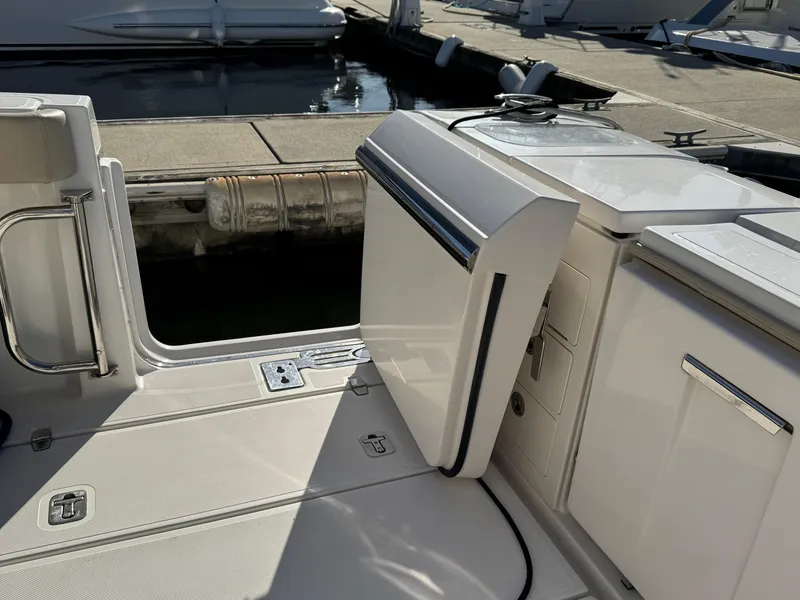 Slide: The Image of 2019 Pursuit S 368 Sport boat deck with open storage compartment at marina. - 5