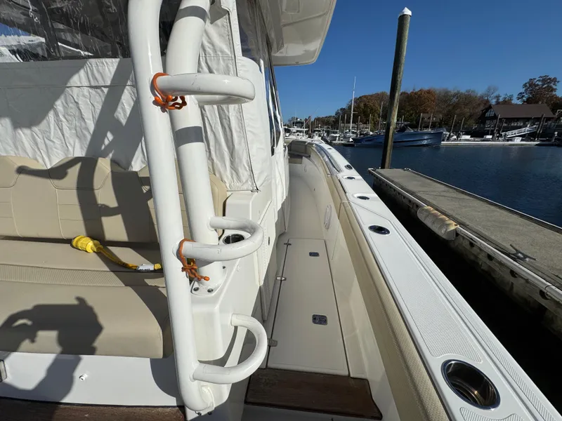 Slide: The Image of 2019 Pursuit S 368 Sport boat docked, showcasing side deck and seating area. - 6