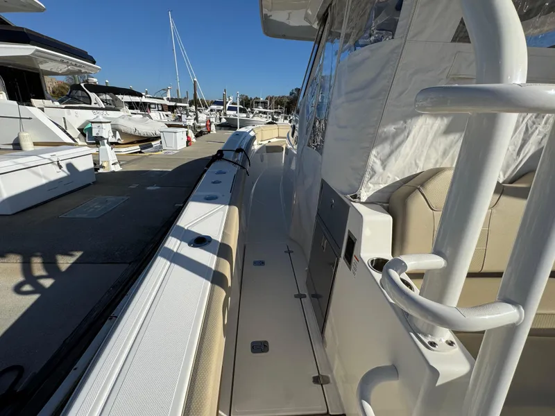 Slide: The Image of 2019 Pursuit S 368 Sport boat docked at marina, showcasing sleek design and spacious deck. - 7