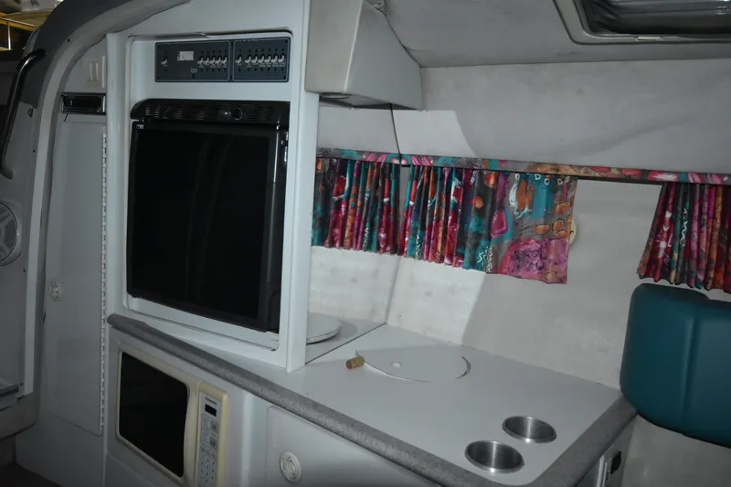 Slide: The Image of Interior of 1997 Formula 330 Sun Sport boat with kitchenette and colorful curtains. - 25