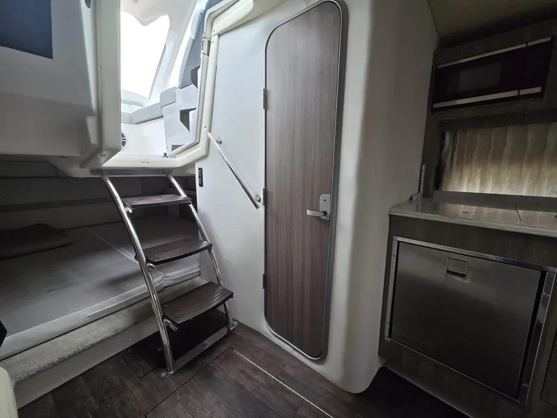 Slide: The Image of Interior of 2020 Regal 33 XO boat with stairs, door, and kitchenette. - 10