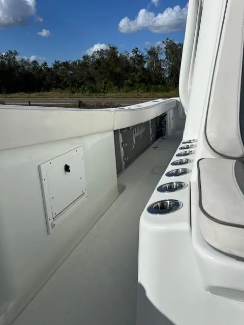 Slide: The Image of 2010 Yellowfin 36 boat interior with rod holders and seating, under a clear blue sky. - 14