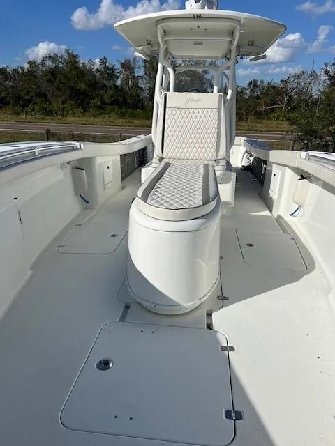Slide: The Image of 2010 Yellowfin 36 boat with cushioned seating and center console, under a clear blue sky. - 16