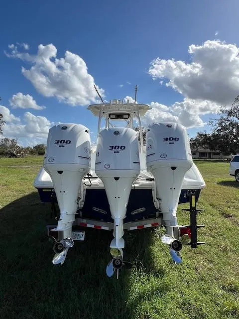 Slide: The Image of 2010 Yellowfin 36 boat with triple 300 horsepower engines, parked on grass under a blue sky. - 3