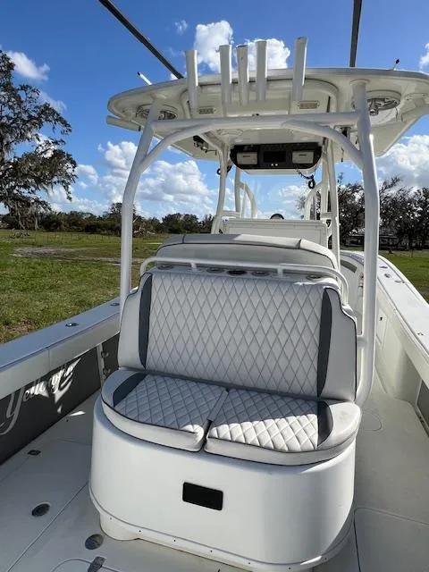 Slide: The Image of 2010 Yellowfin 36 boat with cushioned seating and rod holders, under a clear blue sky. - 7