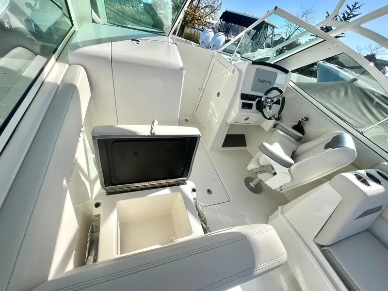 Slide: The Image of 2025 Sailfish 245 DC boat interior with seating, steering wheel, and storage compartments. - 12