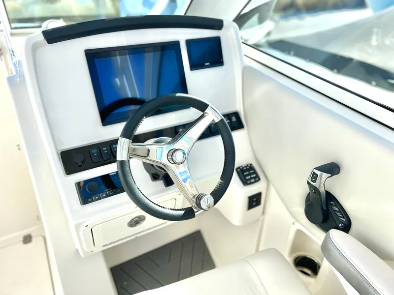 Slide: The Image of 2025 Sailfish 245 DC boat cockpit with steering wheel and modern controls. - 17