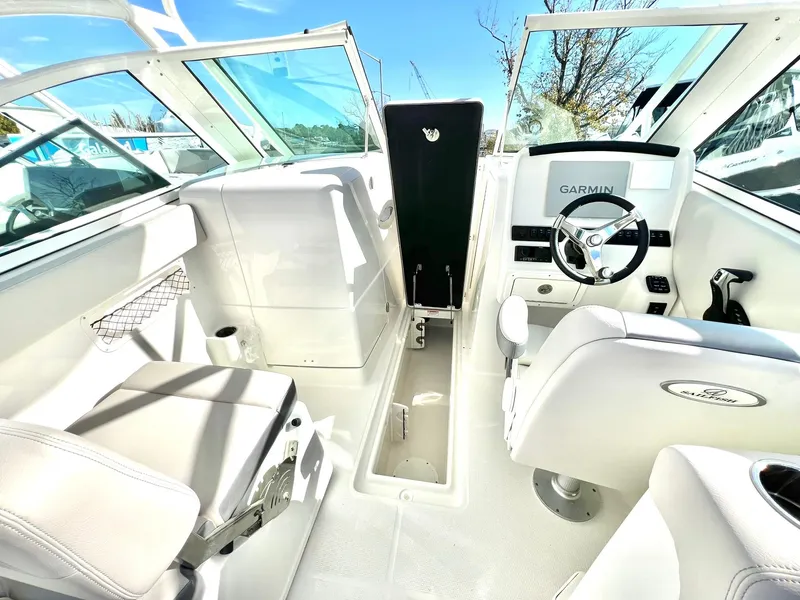 Slide: The Image of 2025 Sailfish 245 DC boat interior with Garmin navigation, white seating, and modern design. - 20