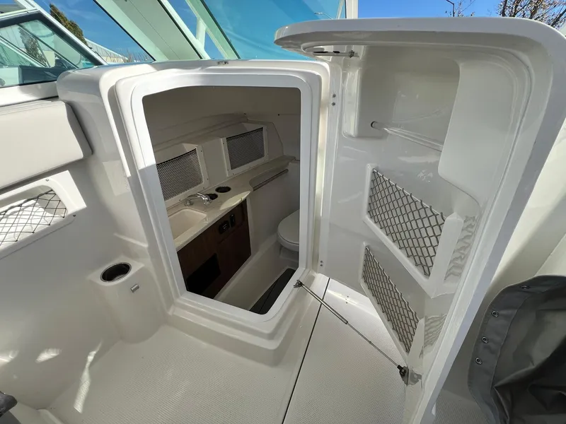 Slide: The Image of 2025 Sailfish 245 DC boat interior with storage compartments and modern design. - 26