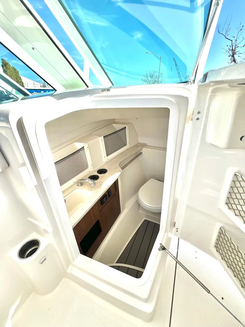 Slide: The Image of 2025 Sailfish 245 DC boat interior with compact cabin and amenities. - 29