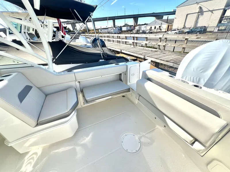 Slide: The Image of 2025 Sailfish 245 DC boat interior with seating, docked at marina. - 3